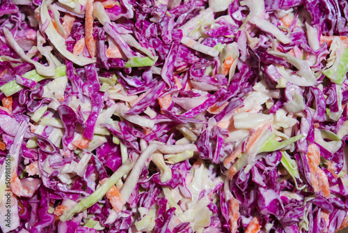 Coleslaw salad made of freshly shredded white, green and red cabbage and grated carrot with homemade salad dressing food texture background photo. Healthy food nutrition or vegetarian diet concept. 