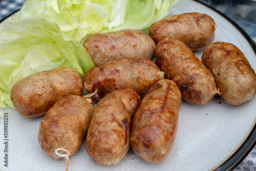 Close up of homemade pork and rice thai sausage with garlic served with lettuce