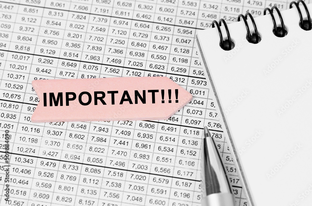 Fototapeta premium On the table among the reports is a notebook, a pen with an arrow with the inscription - Important