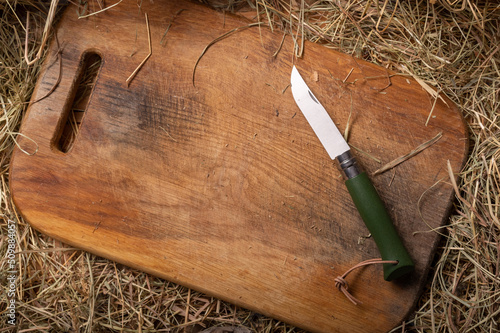Background and texture of a cutting board and a knife with a wooden handle. Knife and cutting board for hay.