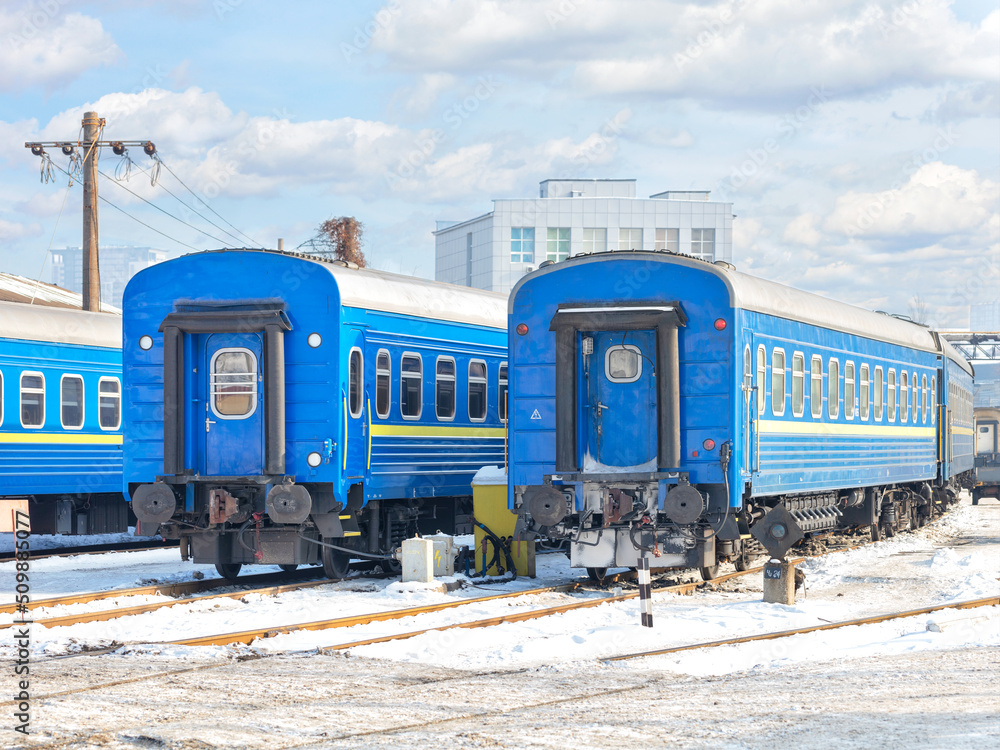 Blue train cars against the background of the winter parking of the railway depot. Blue train cars against the background of the winter parking of the railway depot.