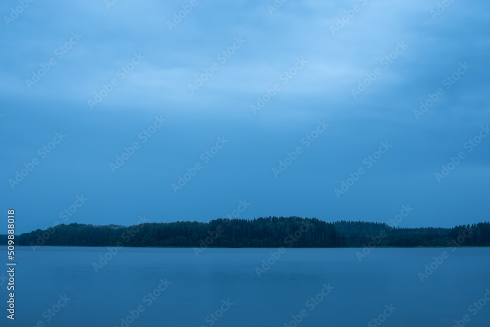 Beautiful evening nearby the lake with blue clouds