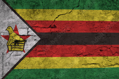 Patriotic cracked wall background in colors of national flag. Zimbabwe