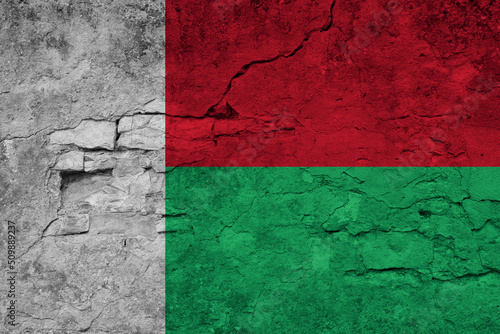 Patriotic cracked wall background in colors of national flag. Madagascar