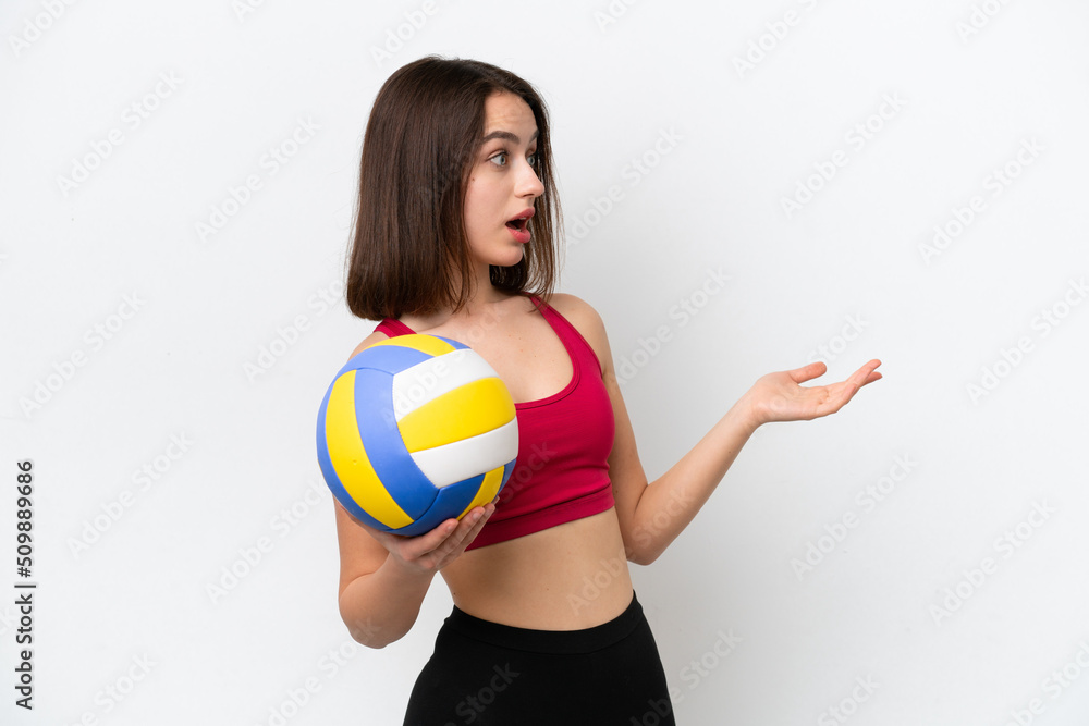 Young Ukrainian woman playing volleyball isolated on white background with surprise expression while looking side Young Ukrainian woman playing volleyball isolated on white background with surprise expression while looking side