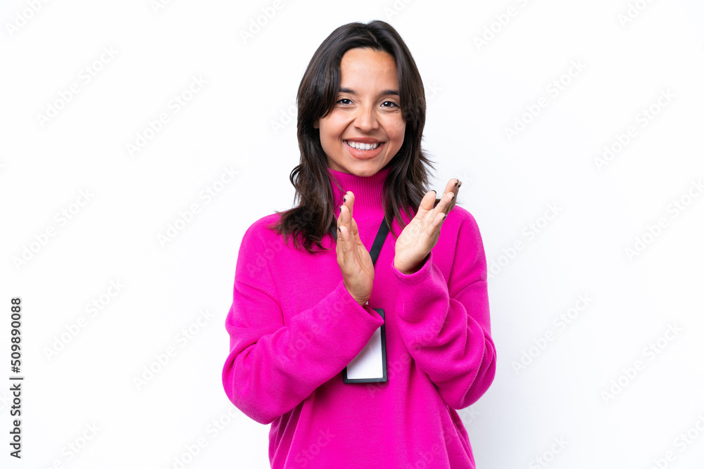 Young hispanic woman with ID card isolated on white background applauding after presentation in a conference Young hispanic woman with ID card isolated on white background applauding after presentation in a conference