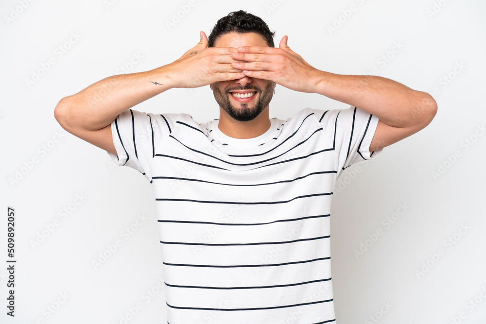 Young Arab handsome man isolated on white background covering eyes by hands and smiling Young Arab handsome man isolated on white background covering eyes by hands and smiling