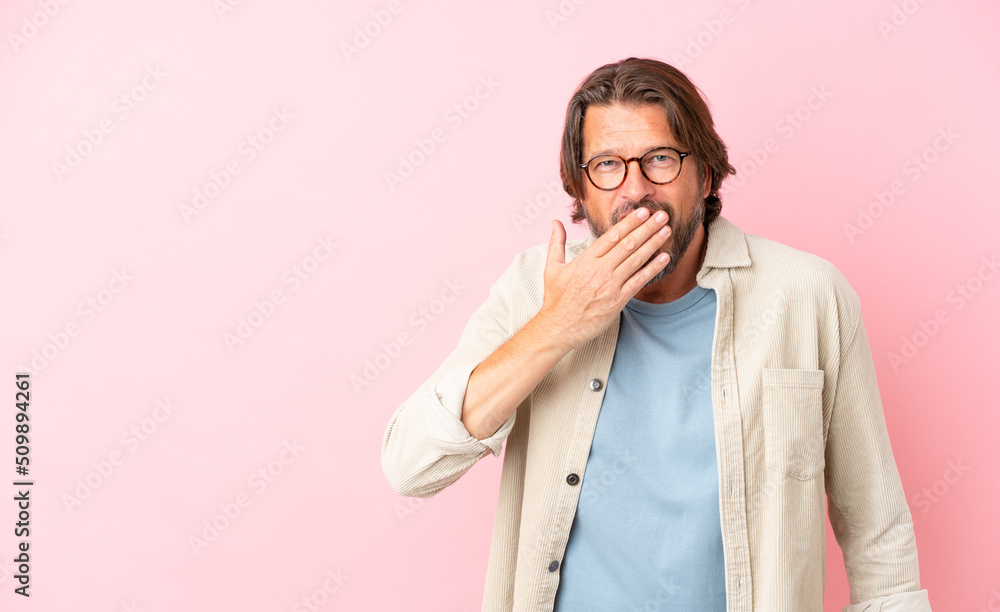 Senior dutch man isolated on pink background happy and smiling covering mouth with hand