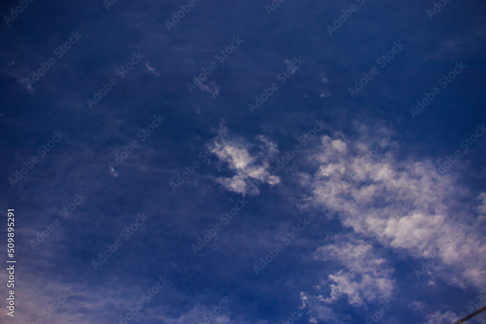 tufts of white clouds lit by the sun, blown by the winds, scattered under the blue sky. tufts of white clouds lit by the sun, blown by the winds, scattered under the blue sky.