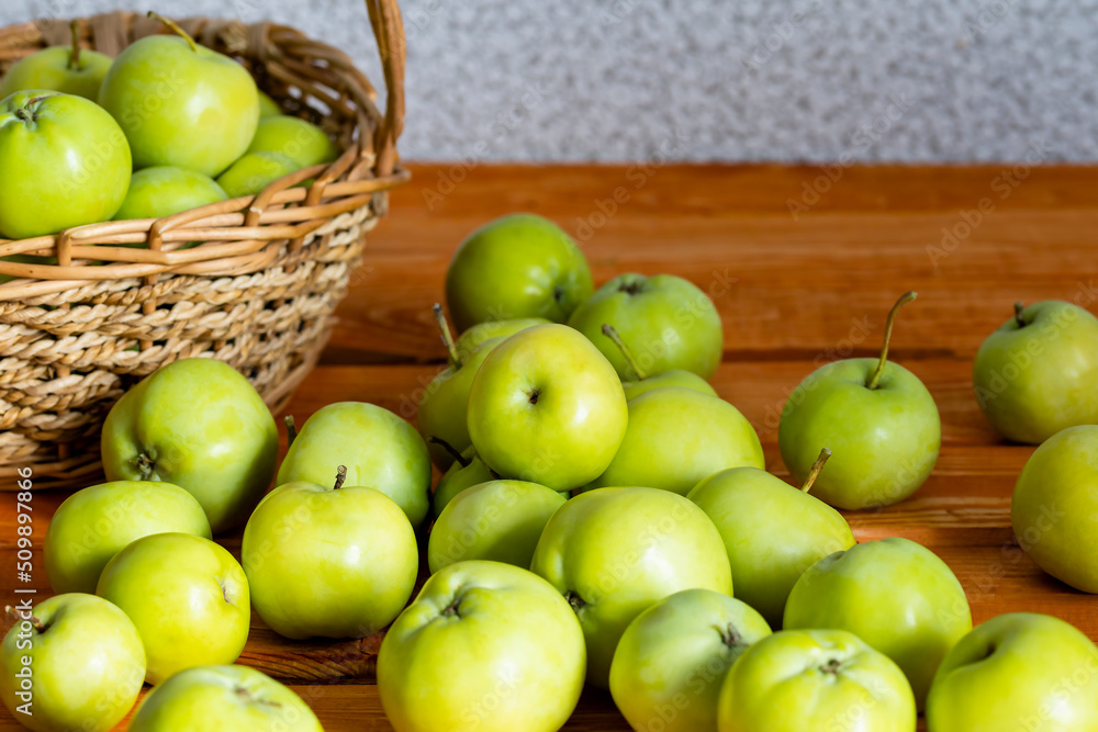 Composition with juicy green apples in wicker basket on table. Copy space Composition with juicy green apples in wicker basket on table. Copy space