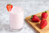 Strawberry smoothie or milkshake in a glass on the table with strawberries. Healthy food or drink. selective focus
