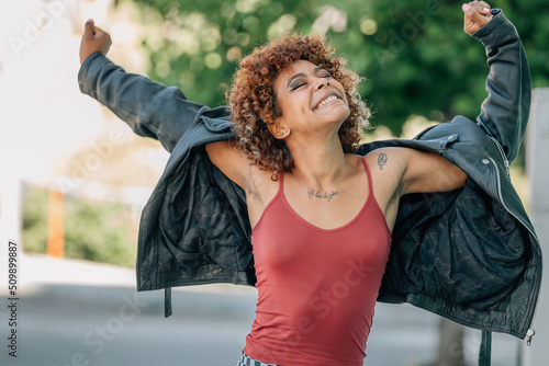 Canvas Print young urban girl smiling and dancing happily in the street