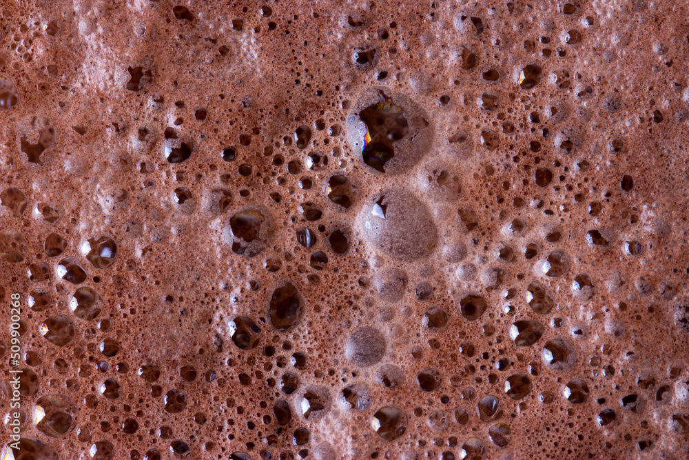Chocolate milk texture in glass cup with small bubbles Chocolate milk texture in glass cup with small bubbles