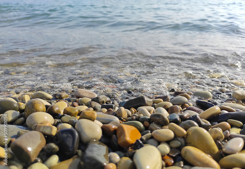 Pebble stones on sea shore natural background. Soft partial focus