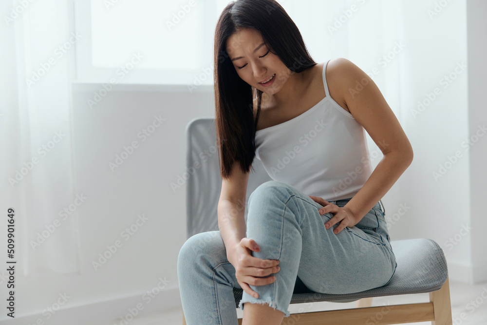 Cramp Broken Toe Broken Bone in Leg. Tormented suffering tanned beautiful young Asian woman touch leg at home interior living room. Injuries Poor health Illness concept. Cool offer Banner Cramp Broken Toe Broken Bone in Leg. Tormented suffering tanned beautiful young Asian woman touch leg at home interior living room. Injuries Poor health Illness concept. Cool offer Banner