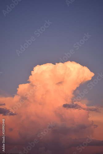 Blue sky and a large cloud with the colors of the sunset