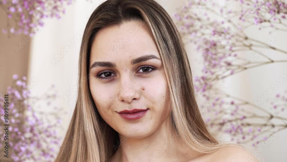 Girl's face with clean smooth skin, naked makeup on the background of gypsophila branches in the studio. Model Girl's face with clean smooth skin, naked makeup on the background of gypsophila branches in the studio. Model