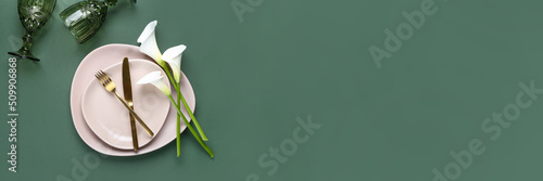 Beautiful table setting with calla lilies on green background. Banner for design