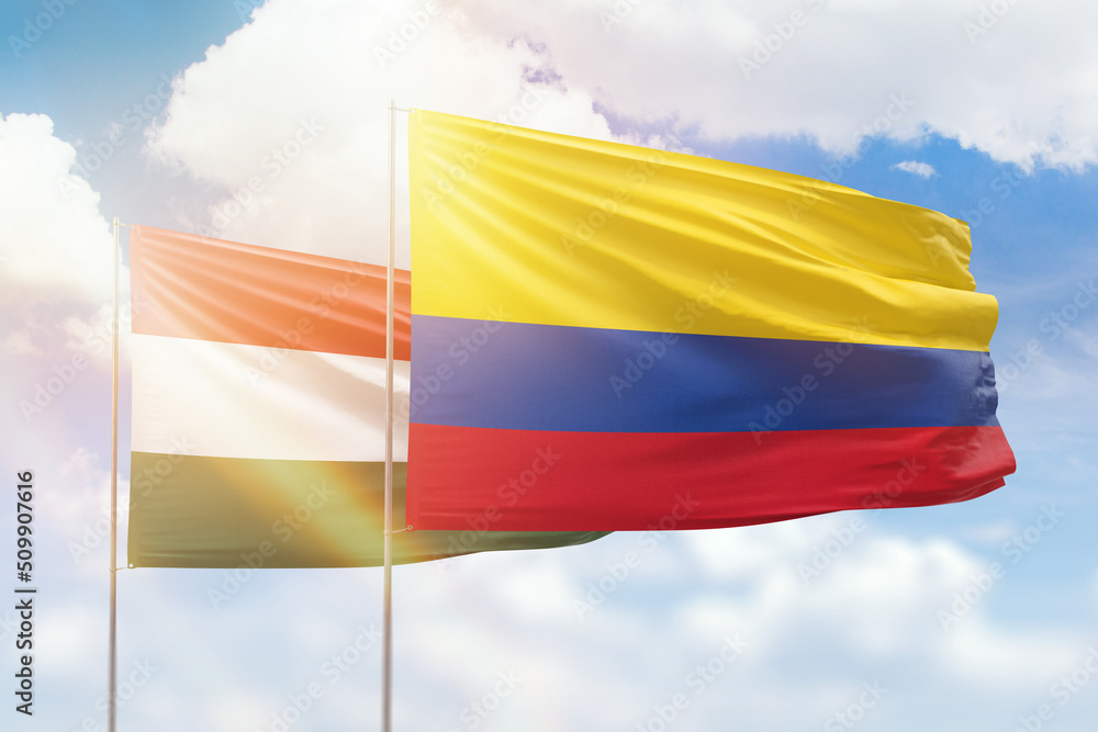 Sunny blue sky and flags of colombia and hungary Sunny blue sky and flags of colombia and hungary