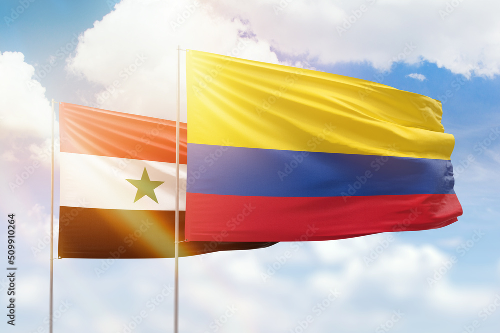 Sunny blue sky and flags of colombia and syria Sunny blue sky and flags of colombia and syria