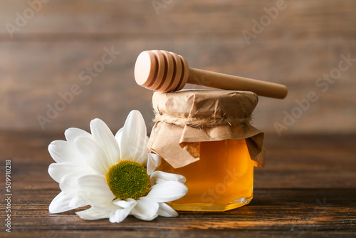 Honey bonbonniere and chrysanthemum flower on wooden background