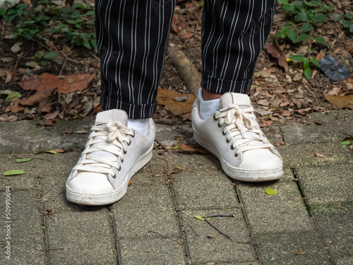 Woman Wearing Black Striped Trousers  White Socks and Off-White Shoes