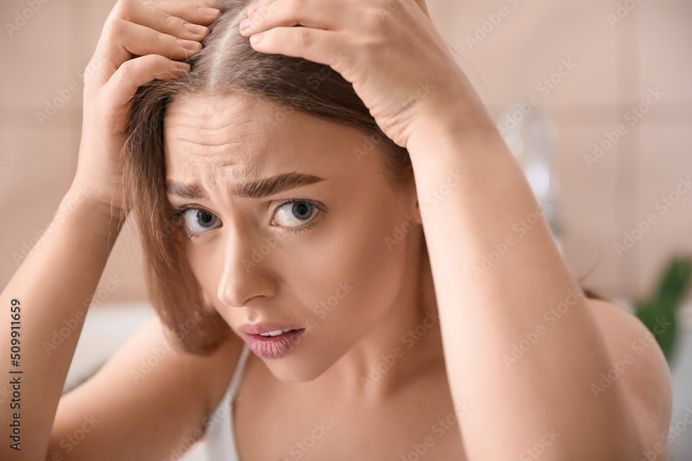 Naklejka premium Stressed young woman with hair loss problem at home