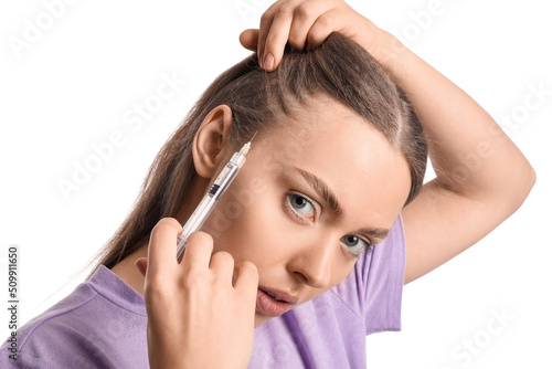 Young woman with hair loss problem giving herself injection on white background