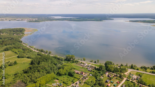Aerial view of lake with sky reflection. Blue lake and green forest. Image for design. Space for text.