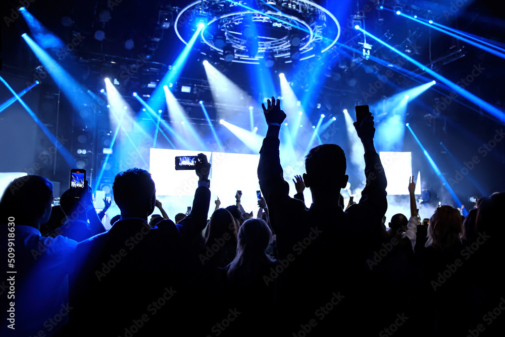 Happy crowd with raised hands at a rock concert.