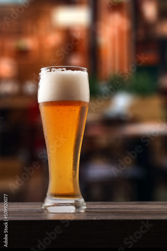 Glass of beer on counter in pub.