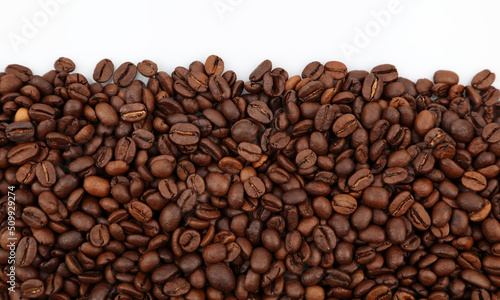 Closeup of roasted brown coffee beans on plain background