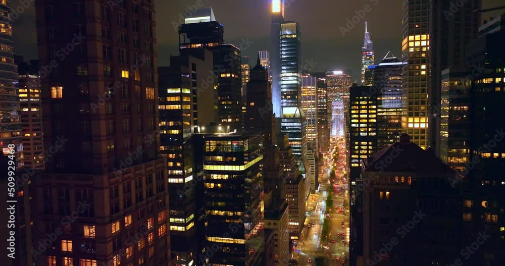 Amazing skyscrapers with lights on. Drone rising over glamorous buildings at night. Cloudy sky background. Amazing skyscrapers with lights on. Drone rising over glamorous buildings at night. Cloudy sky background.