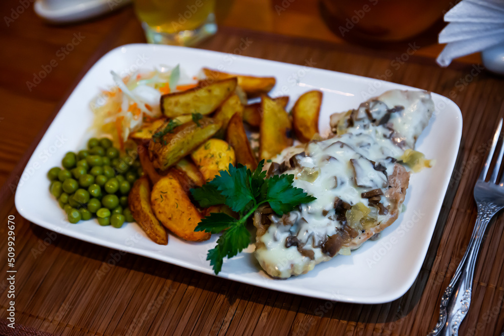 Fried meat with mushrooms and baked potatoes. Russian cuisine
