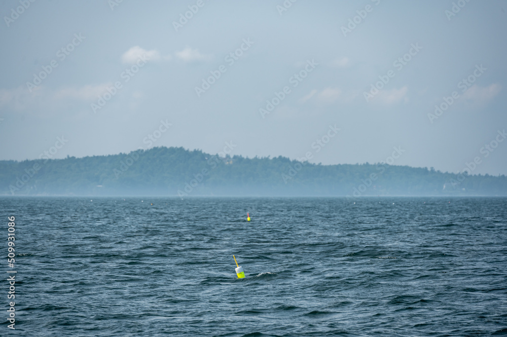 Lobster pot trap buoy floating on a choppy ocean in the Atlantic Ocean