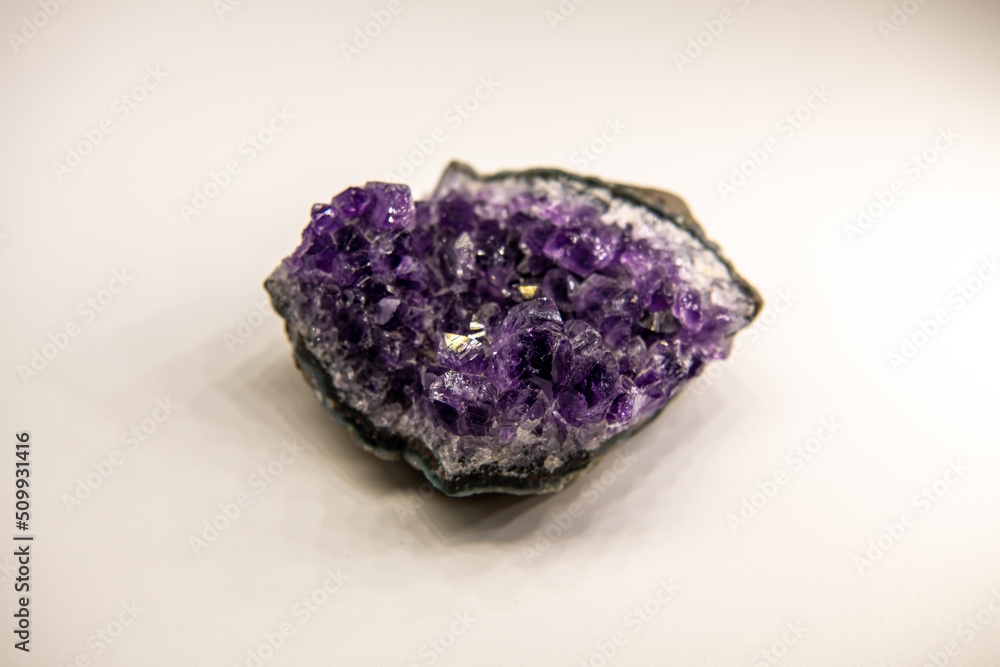 Amethyst geode on the white background, purple gemstone, horizontal background shot, dark toning