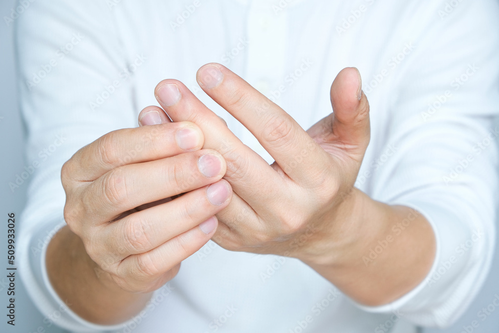 Man's hands are sore and fingers are locked. He squeezed his thumb and