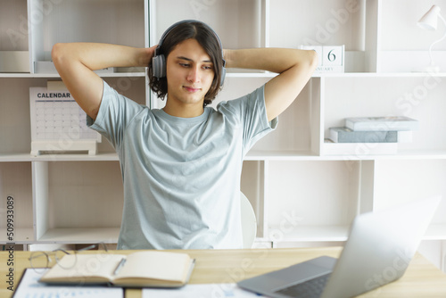 Distance education concept, Teen boy listen music and stretching to relax after study hard online