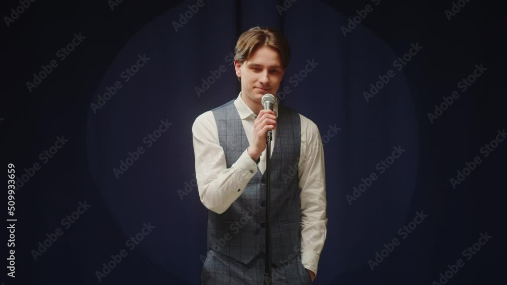 StandUp cafe, comedy concert. Man telling jokes on stage. Male comedian speaks with audience using microphone, humorous monologue. Mentor coach training. Public speaking masterclass. StandUp cafe, comedy concert. Man telling jokes on stage. Male comedian speaks with audience using microphone, humorous monologue. Mentor coach training. Public speaking masterclass.