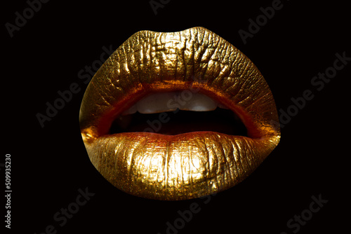 Golden lips with gold lipstick on isolated background. Sensual girl or woman mouth with gold. photo