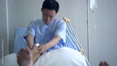 Adult Asian man hurting hos leg and knee in hospital bed photo
