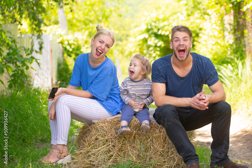 Happy young family of three having fun together launching. Cheerful funny parents playing with son outdoor. Father mother and child playing together. © Volodymyr