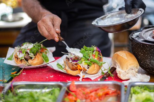 Hands men prepare traditional Argentine sandwiches with herbs and meat.