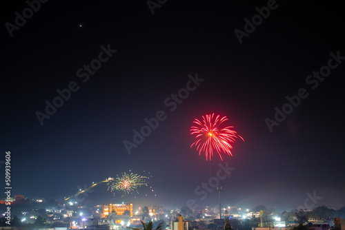 Wide angle shot of fireworks above the city during the 4th of July celebration . Celebration background. Fireworks in the sky above the city, Celebration background. Background of city with firework © Shiv Mer