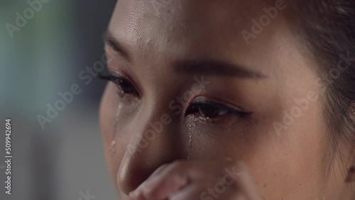 Frustrated and depressed young Asian woman is crying tears coming from her eyes, sad Asian female feel down thinking about problems.