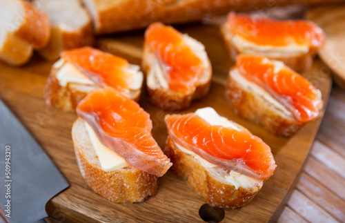 Delicious sandwiches with salmon and butter on a white plate