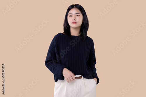 Portrait of a Young modern Asian woman standing and looking at camera over isolated background. © RedcupStudio