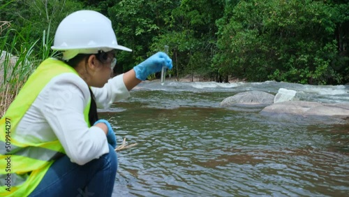 Female environmentalist hands in glove collects water samples from a river to explore and testing for infections. Water and ecology concept