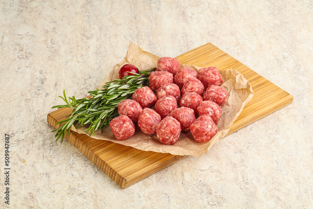 Raw uncooked beef meatballs served rosemary Raw uncooked beef meatballs served rosemary