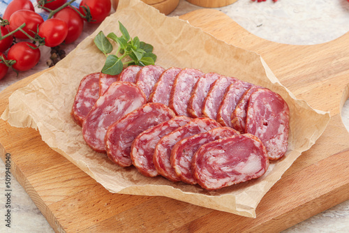 Sliced salami sausages over board